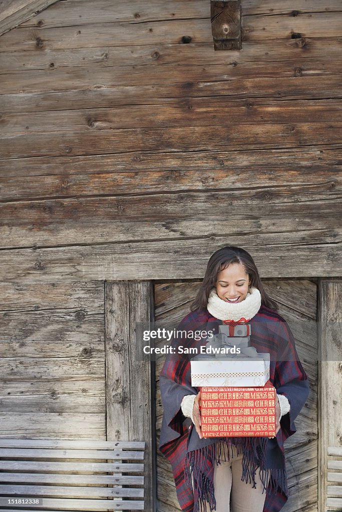 Portrait de femme souriante tenant des cadeaux de Noël devant, en Californie