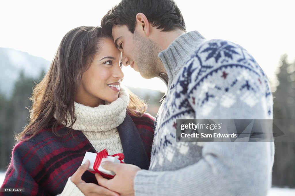 Smiling couple face to face with Christmas gift