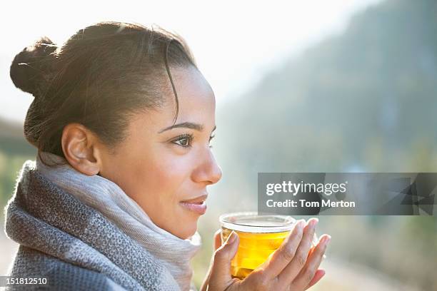 笑顔の女性のクローズアップの紅茶を飲みながら、屋外 - tea hot drink ストックフォトと画像