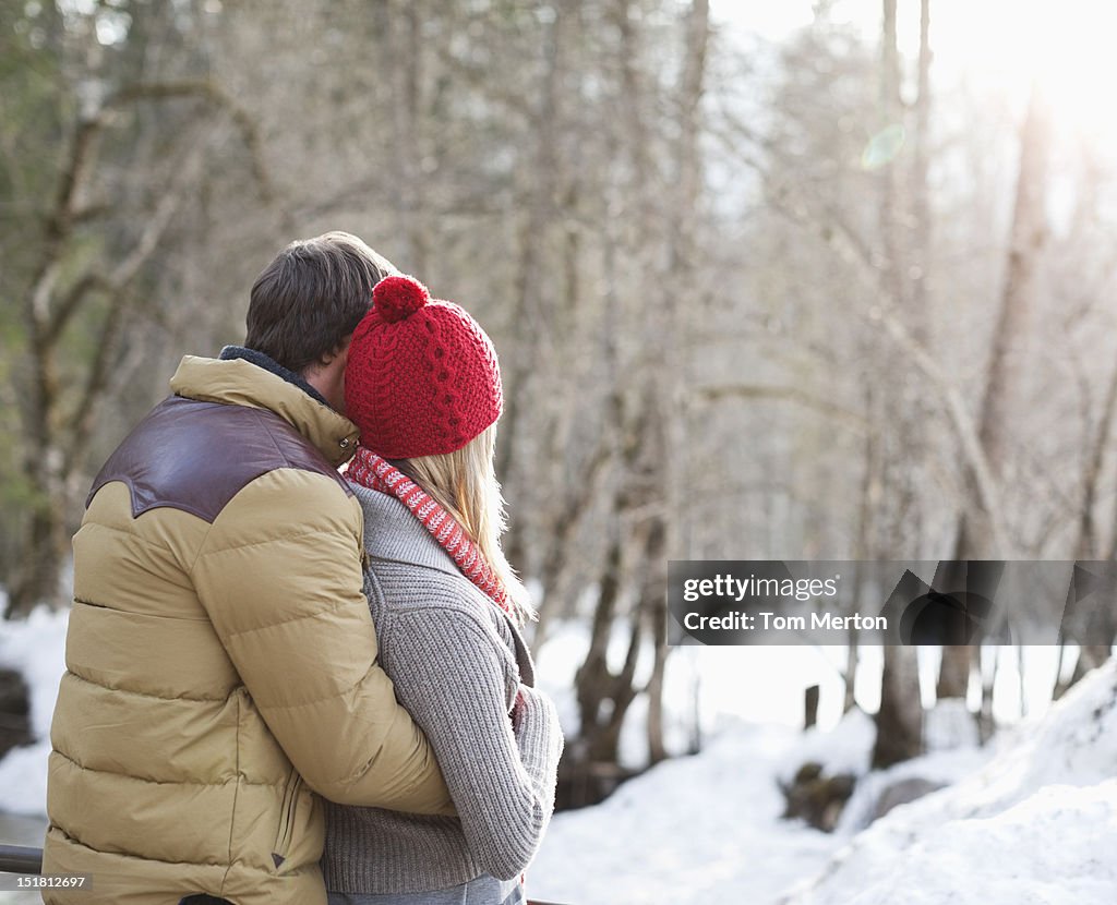Couple hugging in snowy woods