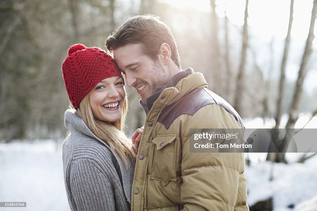 Portrait of smiling couple in snowy woods