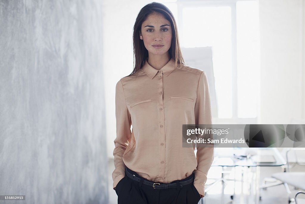 Portrait of confident businesswoman with hands in pockets