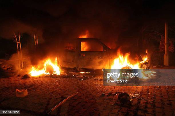 Vehicle and the surrounding area are engulfed in flames after it was set on fire inside the US consulate compound in Benghazi late on September 11,...