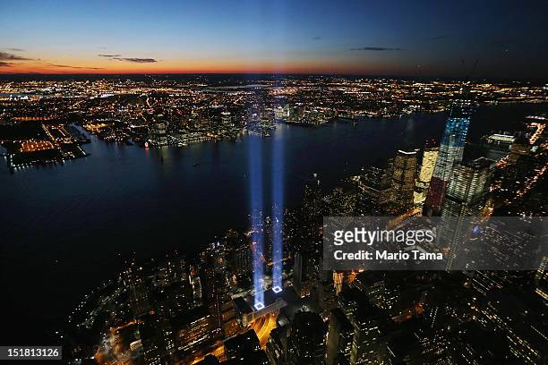 The ‘Tribute in Light’ shines as One World Trade Center rises under construction on the eleventh anniversary of the terrorist attacks on lower...