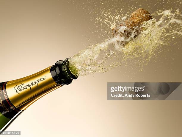 champagne and cork exploding from bottle - champagne bottle imagens e fotografias de stock