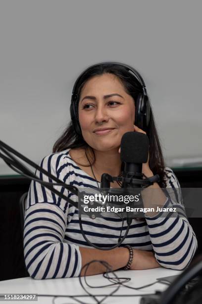 vertical image of a woman with headphones in front of a microphone recording a podcast - media interview stock pictures, royalty-free photos & images