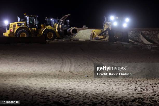 Contractors with the Army Corp of Engineers move sand as part of their beach and dune replenishment project on July 05, 2023 in Bethany Beach,...