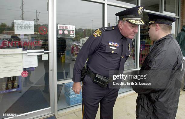 Montgomery Police Chief John Wilson speaks with another officer outside of a state-run liquor store October 24, 2002 in Montgomery, Alabama. Police...