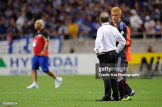 Keisuke Honda of Japan talks with head coach Alberto Zaccheroni after the FIFA World Cup final qualifier match between Japan and Iraq at Saitama...