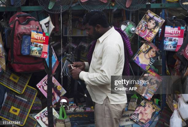 An Indian truck driver buys a belt at a shop also selling adult magazines in Sanjay Gandhi Transport Nagar, a transport rest area in New Delhi on...