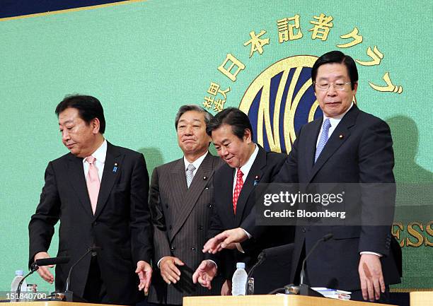 Candidates for leader of the Democratic Party of Japan return to their seats after shaking hands during a debate at the Japan National Press Club in...