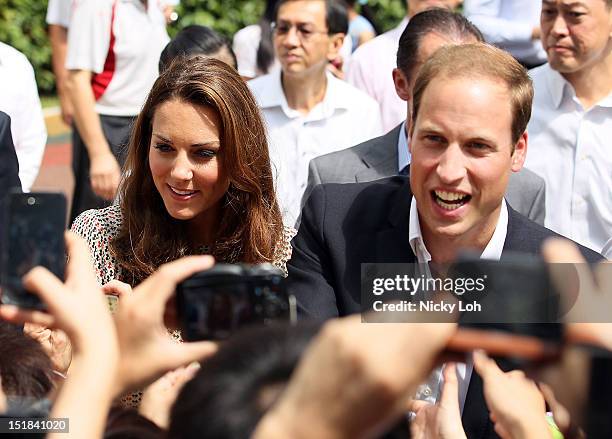 Prince William, Duke of Cambridge and Catherine, Duchess of Cambridge greet fans during a visit to the Strathmore Green residential district as part...