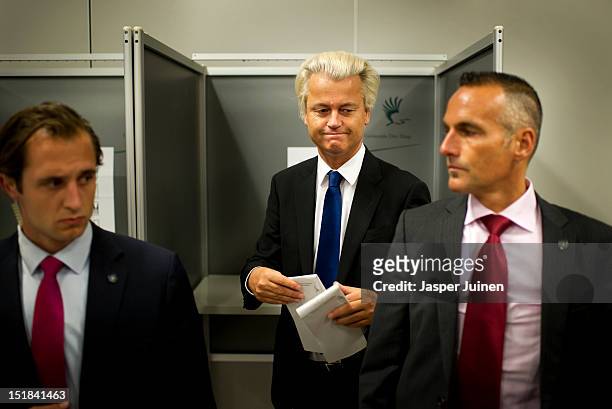 Geert Wilders of the Freedom Party walks in between security men to cast his ballot for the Dutch parliamentary elections in a polling station on...