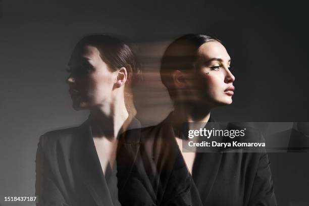 a businesswoman on a dark background, shot with a multi-exposure on a long shutter speed. the concept of fatigue, planning, multitasking. - turn stock pictures, royalty-free photos & images