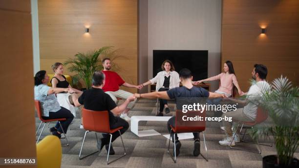 group therapy professional leading group therapy session and meditating - drug rehab stock pictures, royalty-free photos & images