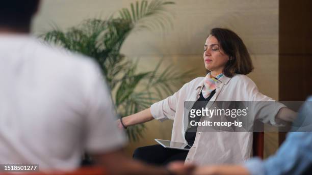 group therapy professional leading group therapy session and meditating - connected mindfulness work stock pictures, royalty-free photos & images