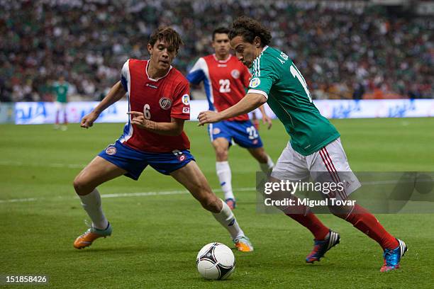 Andres Guardado of Mexico drives the ball and Jose Salvatierra of Costa Rica defends during a match between Mexico and Costa Rica as part of the...