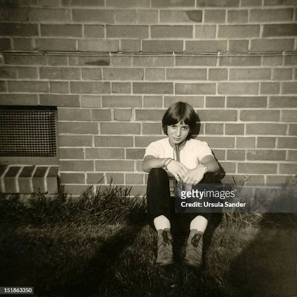 girl sitting in grass - girl wearing boots stock-fotos und bilder