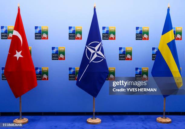 This photograph taken on July 10 shows the Turkish, NATO and Swedish flags displayed as Turkish President and Swedish Prime Minister attend a meeting...