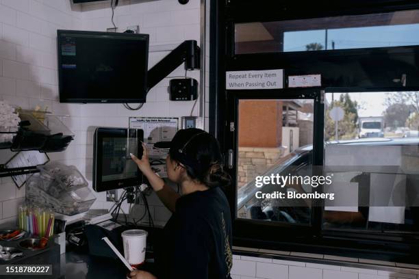 Worker prepares an order received through a Presto Automation drive-thru chatbot at a Del Taco restaurant in Riverside, California, US, on June 29,...