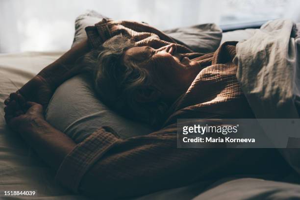 senior woman sleeping in bed at home. - beautiful women bed stockfoto's en -beelden