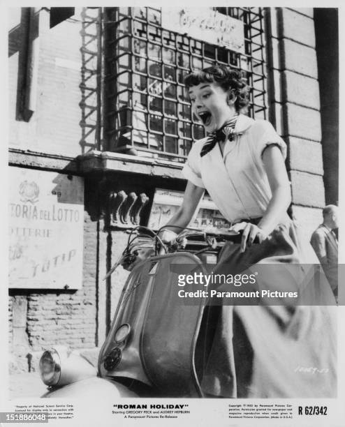 Belgian-born actress Audrey Hepburn riding a motor scooter through Rome in a publicity still for 'Roman Holiday', directed by William Wyler, 1953.