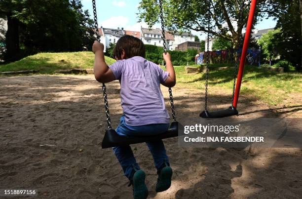 Boy swings at a playground at the Nordstadt, which is considered a social hotspot, with high unemployment, poverty and crime, in Dortmund, western...