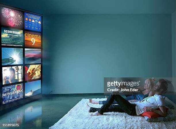 couple watching multiple tv screens - kunst cultuur en vermaak stockfoto's en -beelden