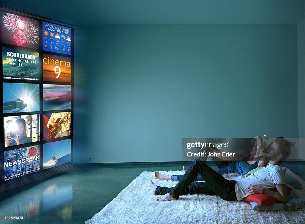 Couple Watching Multiple TV Screens
