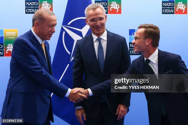 Turkish President Tayyip Erdogan and Swedish Prime Minister Ulf Kristersson shake hands in front of NATO Secretary-General Jens Stoltenberg prior to...