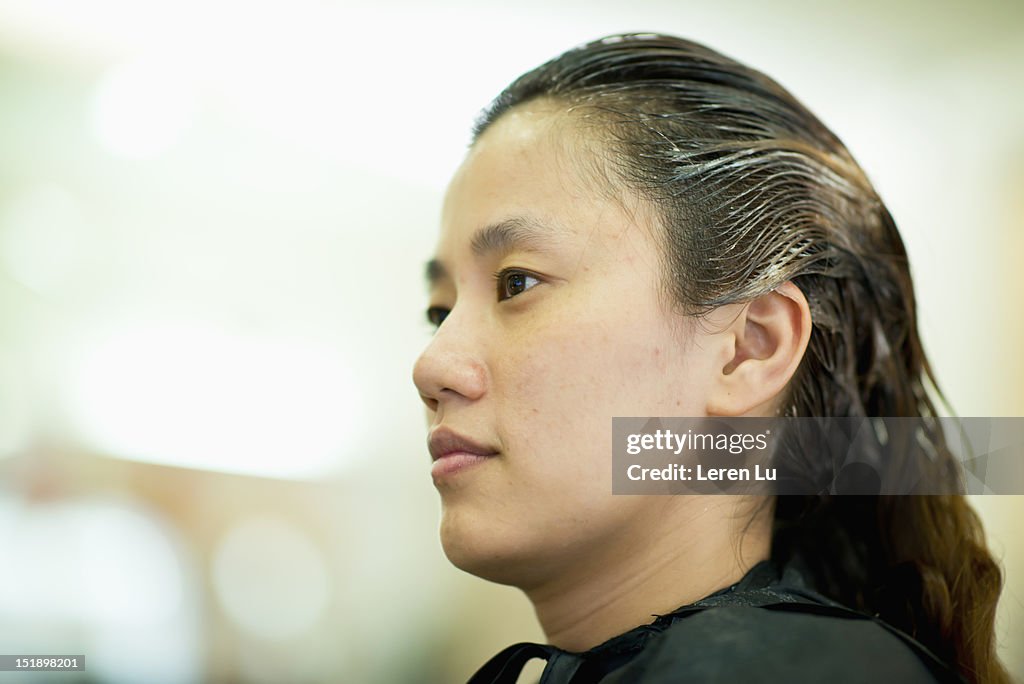 Young woman have hair colored in hair salon