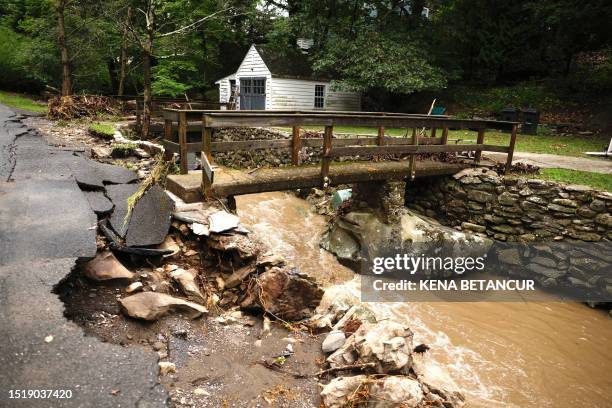 Road is damaged as water in a creek rushes after heavy rainfall in Cornwall-On-Hudson, New York, on July 10, 2023. The northeastern United States was...