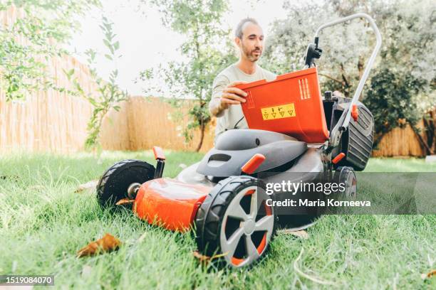 man using a lawn mower in his back yard. - electric mower stock pictures, royalty-free photos & images