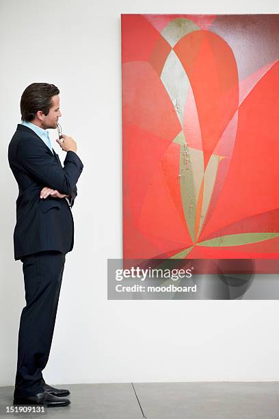 side view of a man looking intensely towards painting - art museum stock pictures, royalty-free photos & images