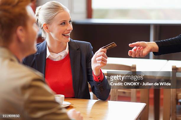 woman paying bill by credit card - debit cards credit cards accepted stock pictures, royalty-free photos & images