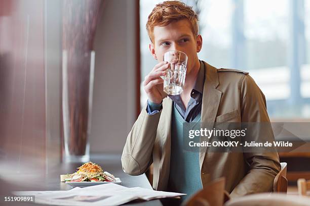 man sitting in a restaurant and drinking water - salat im glas stock-fotos und bilder