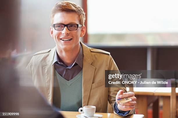 man paying bill by credit card in a restaurant - debit cards credit cards accepted stock pictures, royalty-free photos & images