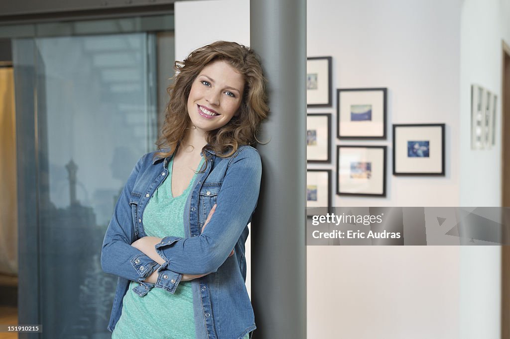 Happy woman leaning against a column