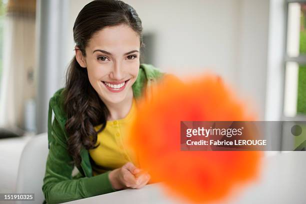 happy woman holding a feather duster - feather duster stock pictures, royalty-free photos & images