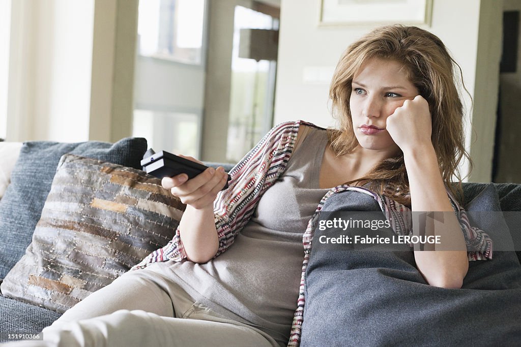 Woman watching television and looking serious