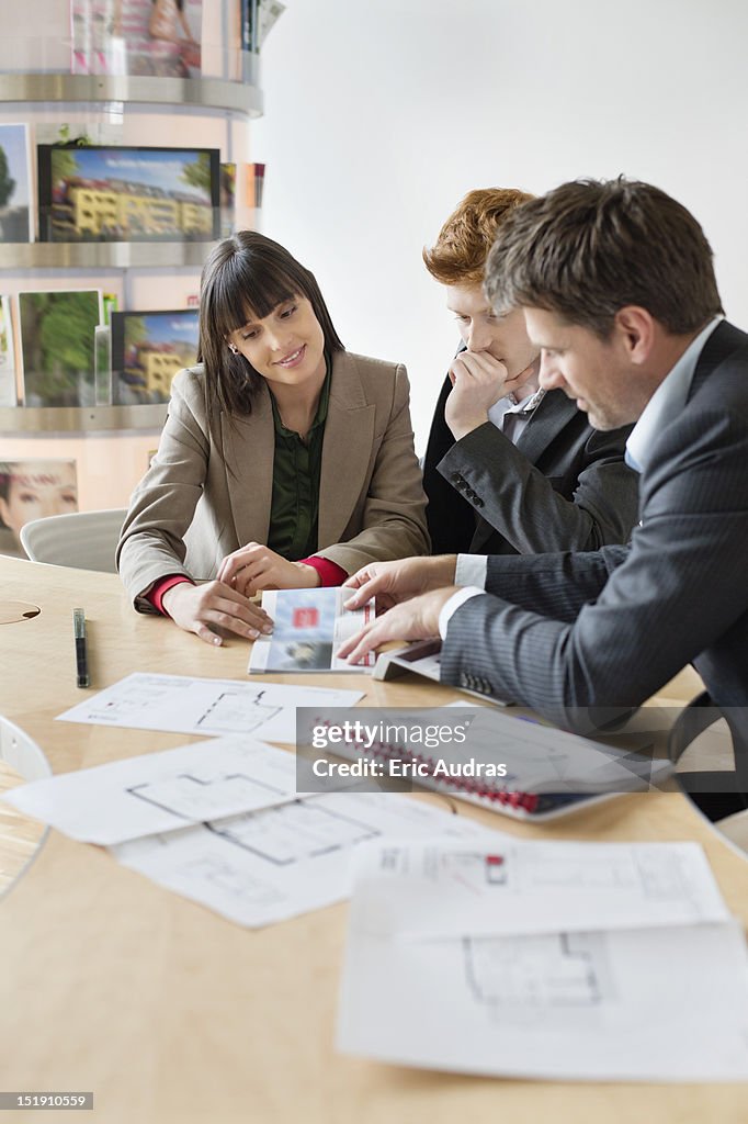 Real estate agent discussing property documents to his clients