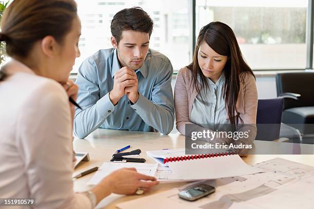 real estate agent discussing property documents to his clients - flyers business people stockfoto's en -beelden