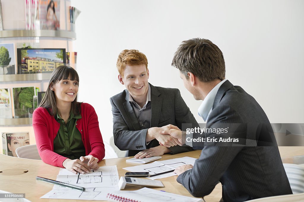 Real estate agent discussing property documents to his clients