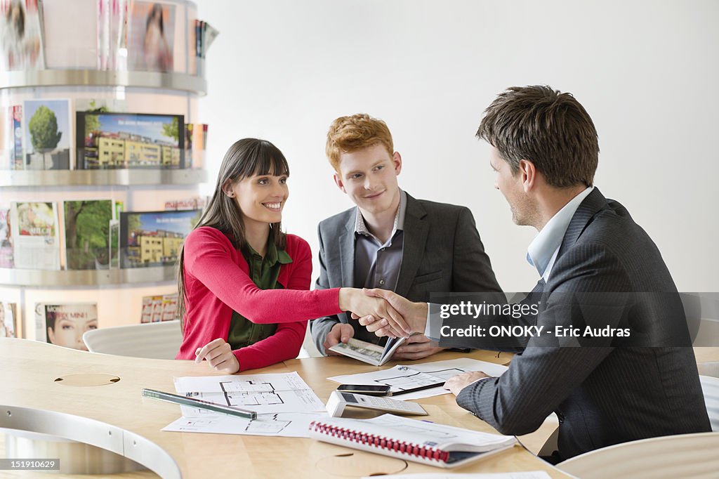 Real estate agent discussing property documents to his clients