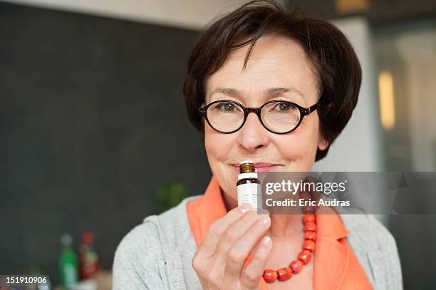 woman smelling aromatherapy oil - aromatherapy stock pictures, royalty-free photos & images