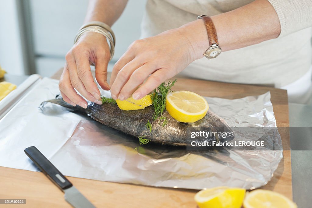 Elderly woman preparing seafood in a kitchen