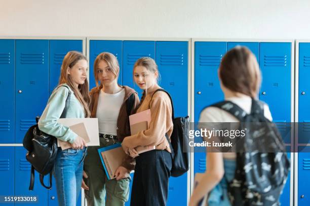 teenage girls gossiping about their friend - bullying stock pictures, royalty-free photos & images