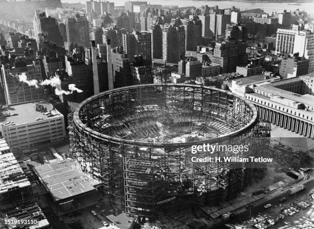 High-angle view of construction work underway on the new Madison Square Garden arena, with the tension ring supported on scaffolding in the centre of...