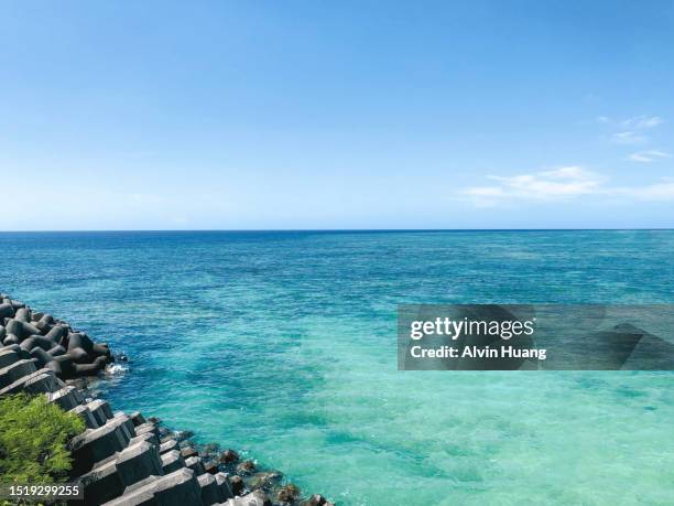 the clean and transparent seawater, along with the blue sky and white clouds, of miyako island in okinawa, japan. - okinawa blue sky beach landscape stockfoto's en -beelden