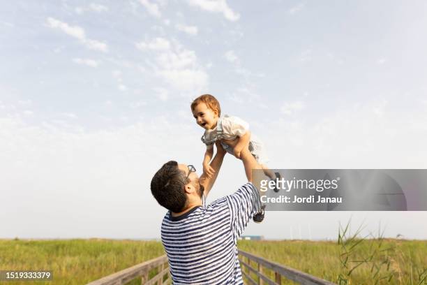 a father lifting his son in the air - tarragona province stock pictures, royalty-free photos & images